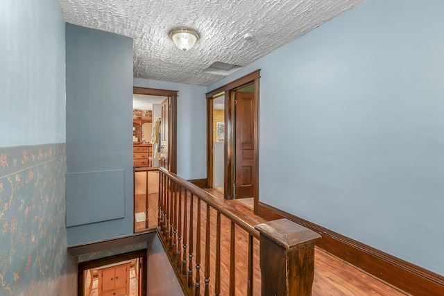 corridor featuring baseboards and an upstairs landing