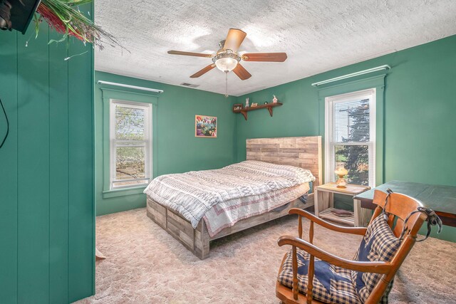 bedroom with carpet flooring, a ceiling fan, a textured ceiling, and visible vents