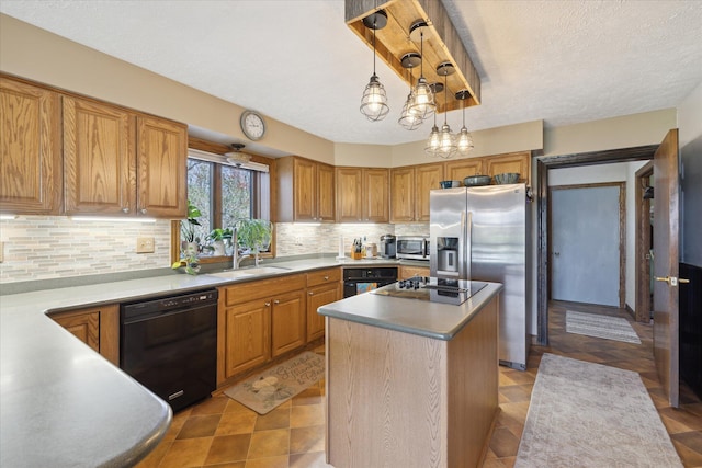 kitchen with decorative backsplash, pendant lighting, a center island, a sink, and black appliances