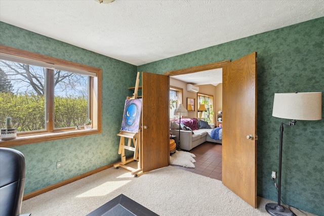 bedroom with an AC wall unit, a textured ceiling, and multiple windows