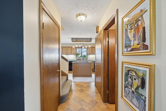 hall featuring a textured ceiling