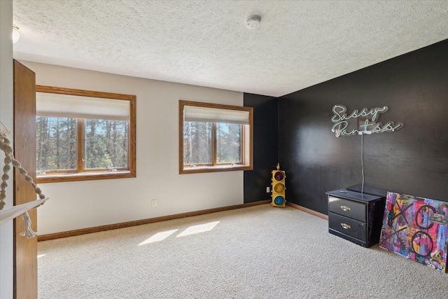 playroom featuring carpet flooring, a textured ceiling, and baseboards