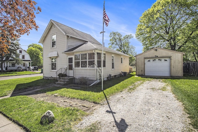 traditional-style house with a detached garage, dirt driveway, an outbuilding, and a front lawn