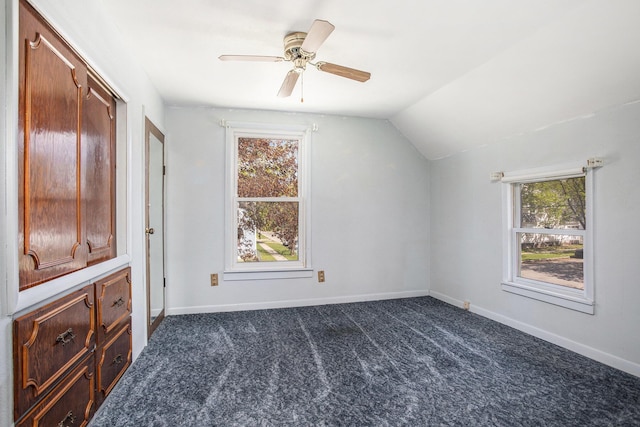 additional living space featuring baseboards, a ceiling fan, vaulted ceiling, and dark colored carpet