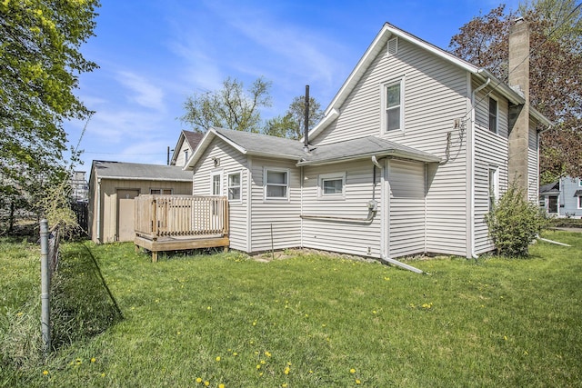 back of house with a lawn, a chimney, and a wooden deck