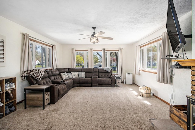 carpeted living area with baseboards and a ceiling fan