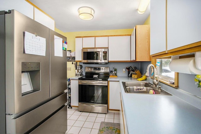 kitchen featuring a sink, light countertops, light tile patterned floors, white cabinets, and stainless steel appliances