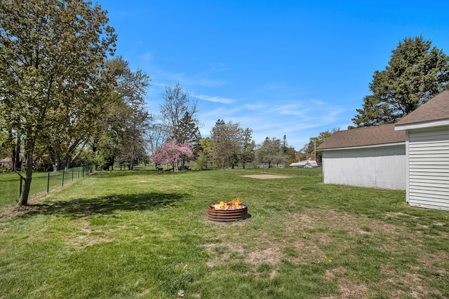 view of yard with fence and an outdoor fire pit