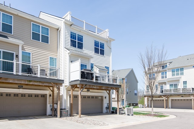 2841 Hardwick Rd, Ann Arbor, MI 48105 - townhome / multi-family property with central air condition unit, concrete driveway, a balcony, and a garage