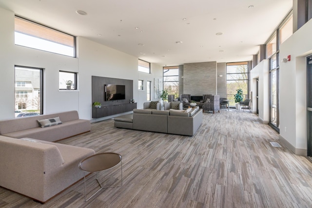 2841 Hardwick Rd, Ann Arbor, MI 48105 - living room with a large fireplace, plenty of natural light, wood finished floors, and a towering ceiling
