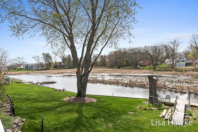 view of yard with a water view and a dock
