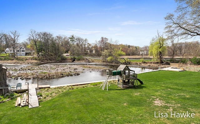 exterior space featuring a water view, a playground, and a yard