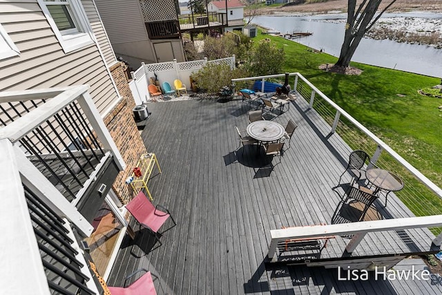 wooden terrace featuring a water view and a yard