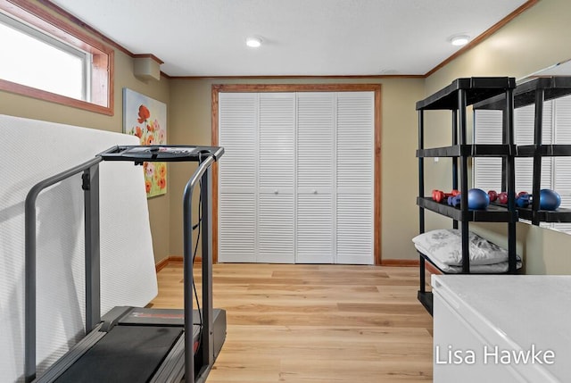 workout area with crown molding, recessed lighting, baseboards, and light wood-style floors