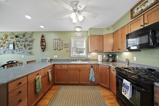 5576 Rays Dr, Onsted, MI 49265 - kitchen with a peninsula, light wood finished floors, a sink, and black appliances