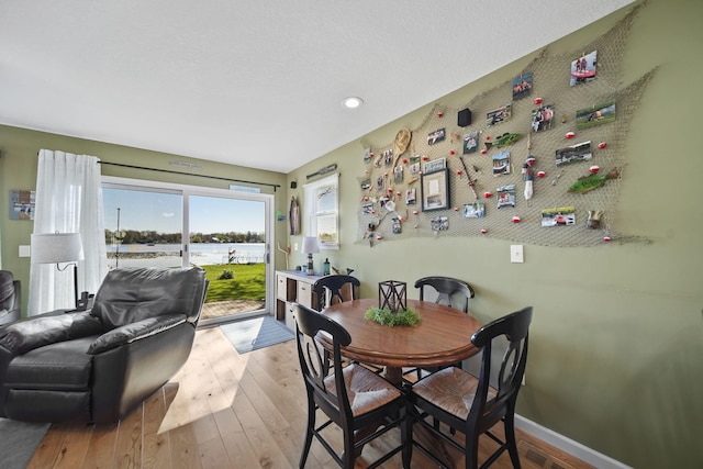 5576 Rays Dr, Onsted, MI 49265 - dining space with recessed lighting, baseboards, a water view, and hardwood / wood-style flooring