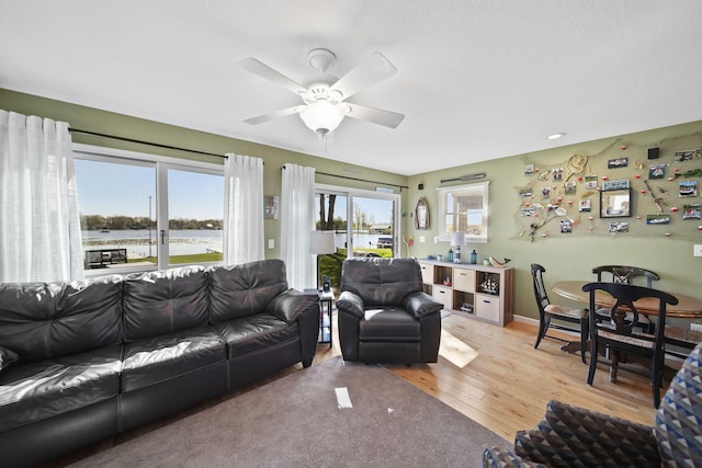 5576 Rays Dr, Onsted, MI 49265 - living room with a ceiling fan, baseboards, a water view, and light wood-type flooring
