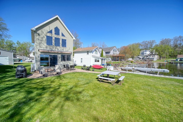 5576 Rays Dr, Onsted, MI 49265 - back of property featuring a lawn, a water view, and a patio area
