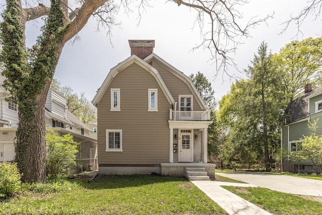 1324 Wells St, Ann Arbor, MI 48104 - view of front facade with a chimney, a front lawn, a gambrel roof, and a balcony
