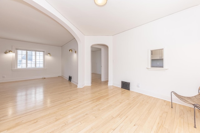 1324 Wells St, Ann Arbor, MI 48104 - spare room with arched walkways, baseboards, wood finished floors, and visible vents