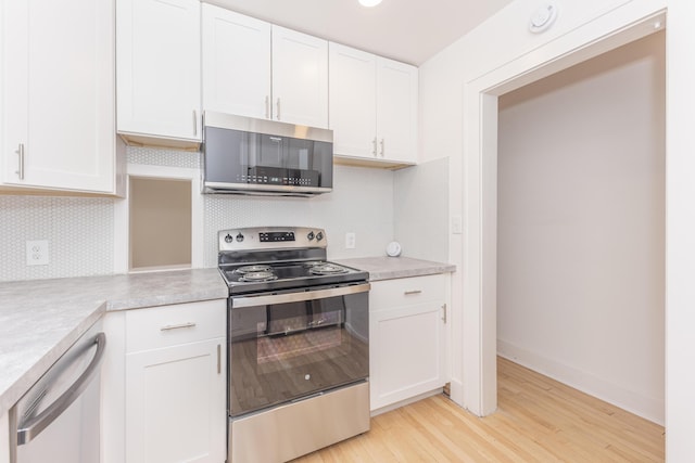 1324 Wells St, Ann Arbor, MI 48104 - kitchen featuring backsplash, light countertops, white cabinets, light wood finished floors, and stainless steel appliances