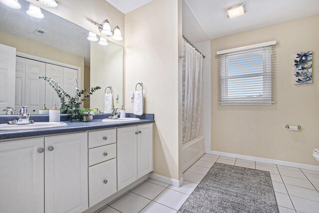 2191 W Linco Rd, Stevensville, MI 49127 - full bathroom with double vanity, tile patterned floors, shower / bath combo with shower curtain, baseboards, and toilet