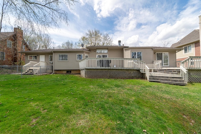 rear view of property featuring a lawn, fence, and a deck