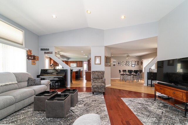 living area with a ceiling fan, dark wood-style floors, and high vaulted ceiling