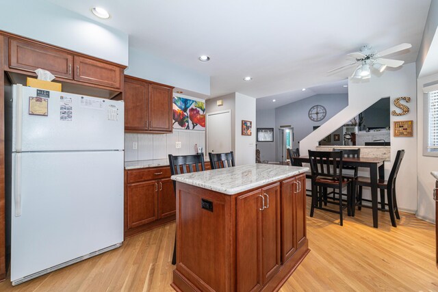 kitchen with freestanding refrigerator, ceiling fan, light wood-type flooring, recessed lighting, and a center island