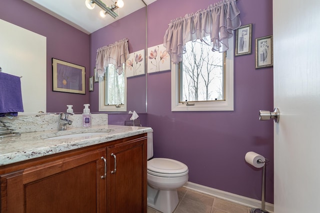 bathroom featuring toilet, baseboards, plenty of natural light, and tile patterned floors