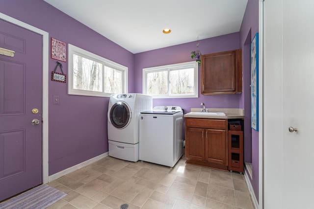 washroom with washing machine and clothes dryer, cabinet space, a sink, recessed lighting, and baseboards