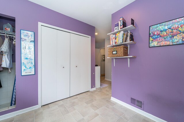 unfurnished bedroom with visible vents, baseboards, and a closet