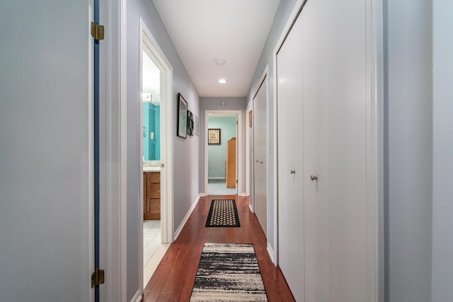 corridor featuring recessed lighting, baseboards, and dark wood finished floors