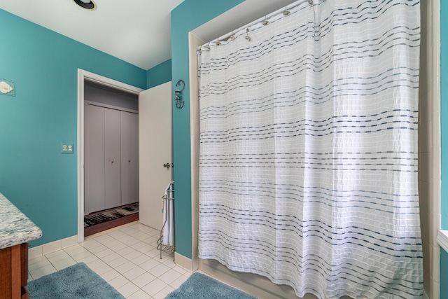 bathroom with vanity, baseboards, tile patterned floors, and shower / bath combo with shower curtain