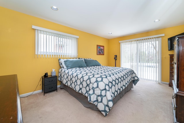 bedroom featuring access to outside, baseboards, light carpet, and multiple windows