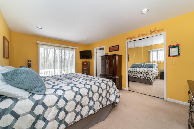 bedroom featuring a closet, recessed lighting, baseboards, and light colored carpet