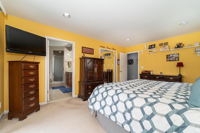bedroom with recessed lighting, baseboards, ensuite bathroom, and light carpet