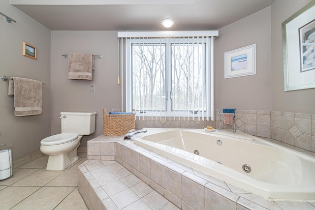 full bath with toilet, tile patterned floors, a tub with jets, and a healthy amount of sunlight