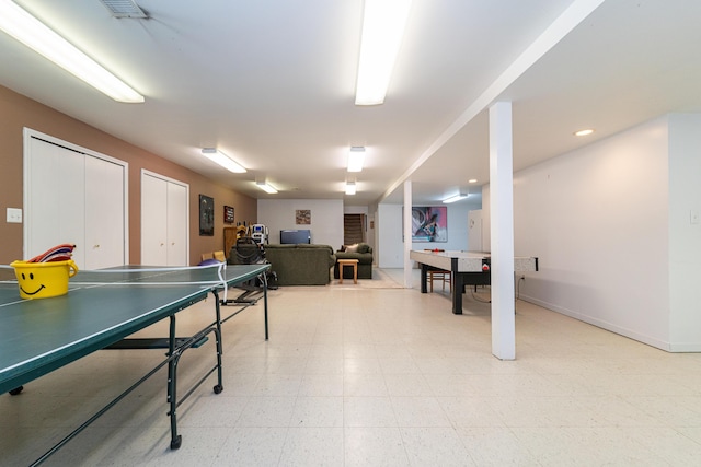 recreation room featuring baseboards, visible vents, and light floors