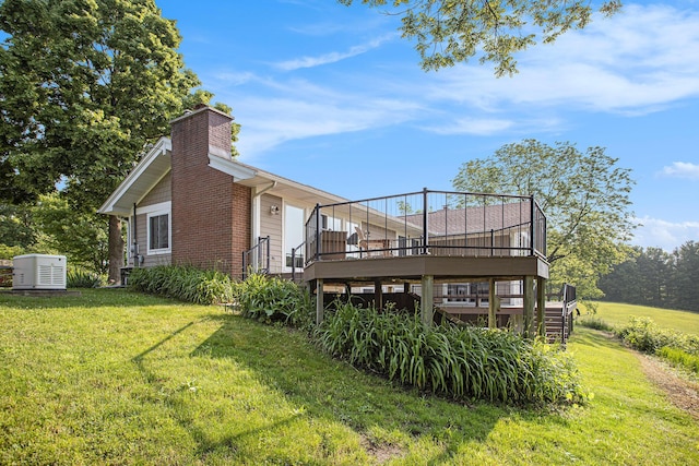 2347 W W Dowling Rd, Delton, MI 49046 - back of house featuring a chimney, a wooden deck, a lawn, and stairs