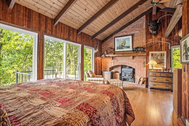 2347 W W Dowling Rd, Delton, MI 49046 - bedroom featuring a wooden ceiling with exposed beams, wooden walls, a wood stove, hardwood / wood-style flooring, and access to outside
