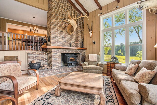 2347 W W Dowling Rd, Delton, MI 49046 - living area with a wood stove, wood finished floors, beam ceiling, wood walls, and high vaulted ceiling