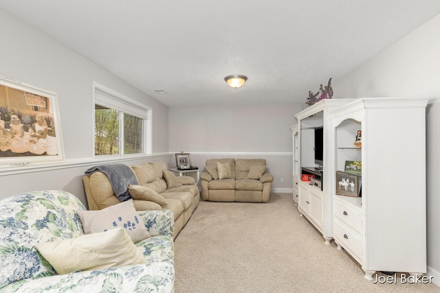 living area with light colored carpet and baseboards