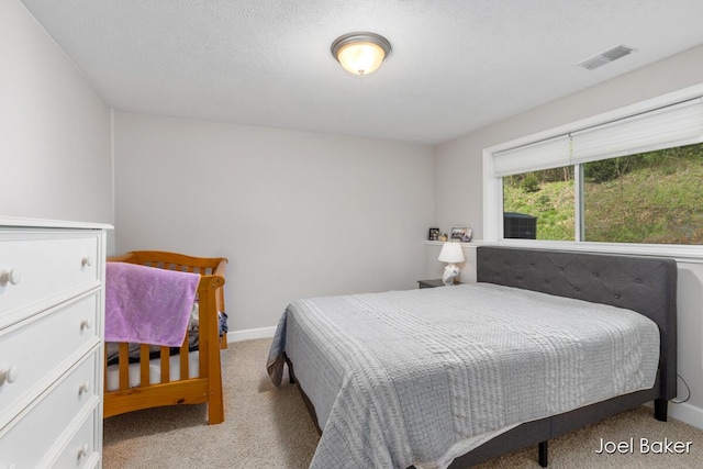 bedroom featuring baseboards, visible vents, and carpet