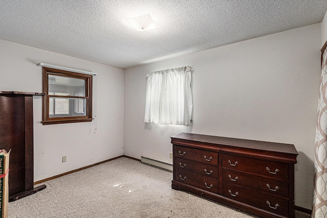 14770 Panu Ave, Kaleva, MI 49645 - unfurnished bedroom with a baseboard heating unit, light colored carpet, a textured ceiling, and baseboards