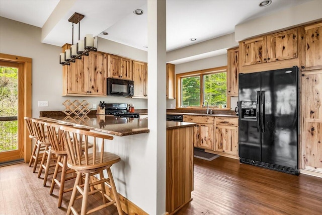 80220 Linden Hills St, Covert, MI 49043 - kitchen featuring black appliances, dark wood-type flooring, a kitchen breakfast bar, a peninsula, and recessed lighting