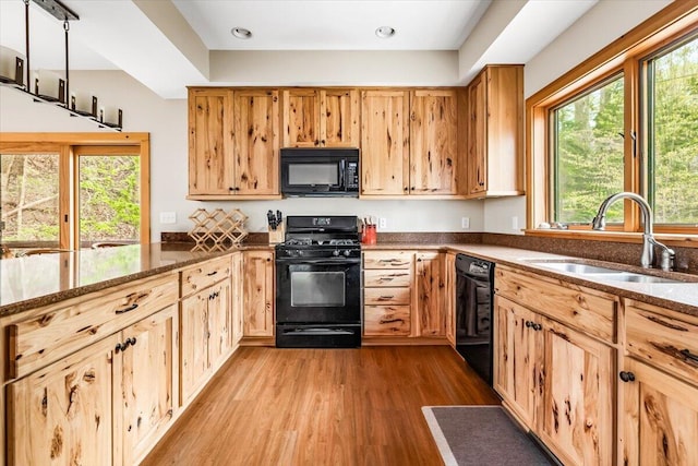 80220 Linden Hills St, Covert, MI 49043 - kitchen with black appliances, a sink, light wood-style flooring, dark stone counters, and recessed lighting
