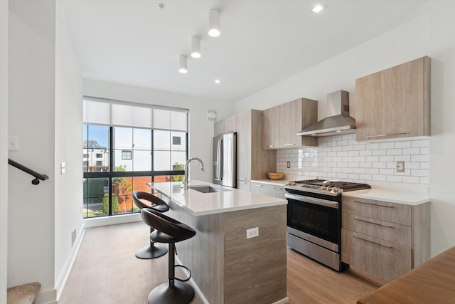 533 E Harrison Unit 3, Royal Oak, MI 48067 - kitchen featuring appliances with stainless steel finishes, modern cabinets, light countertops, light brown cabinets, and wall chimney exhaust hood