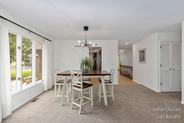 carpeted dining space featuring a chandelier and baseboards