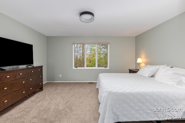 bedroom with baseboards and light colored carpet